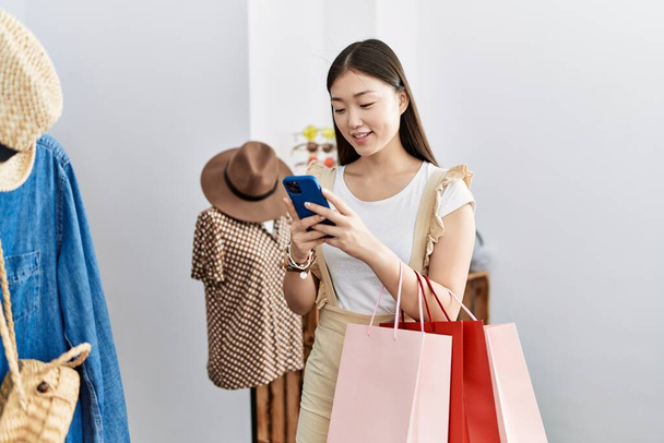 Young asian woman going shopping using smartphone at retail shop - Foto, imagen