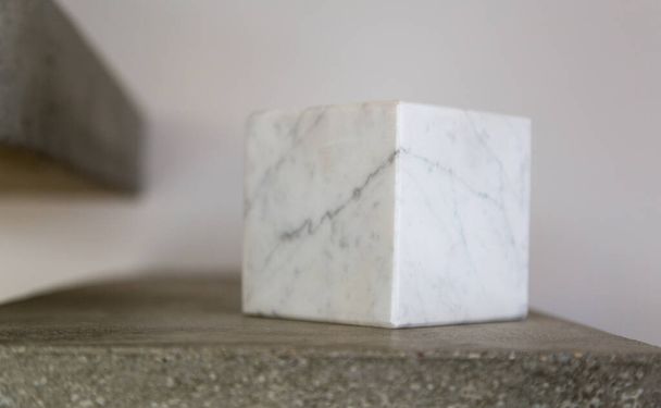 Carrara marble cube on a concrete step block; copy space composition - Φωτογραφία, εικόνα