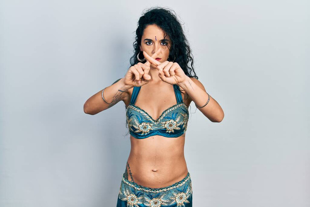 jonge vrouw dragen bindi en traditionele buik dans kleding afwijzing expressie kruisen vingers doen negatief teken  - Foto, afbeelding