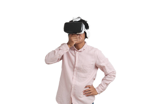 Giovane uomo peruviano stupito indossando cuffie realtà virtuale, isolato. - Foto, immagini