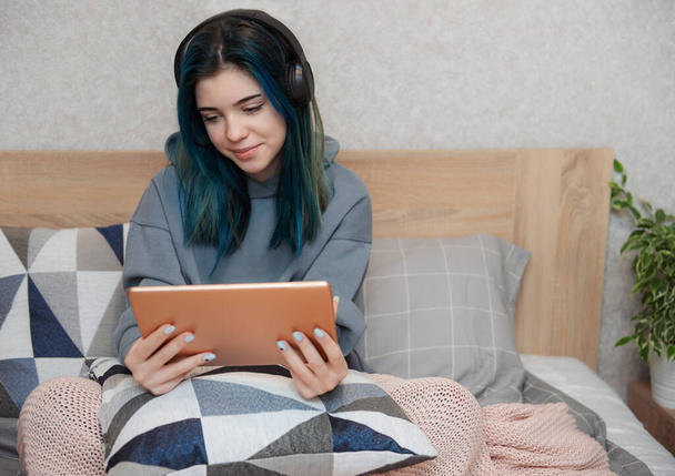 Fiatal tizenéves lány kék haj, tabletta és fülhallgató - Fotó, kép