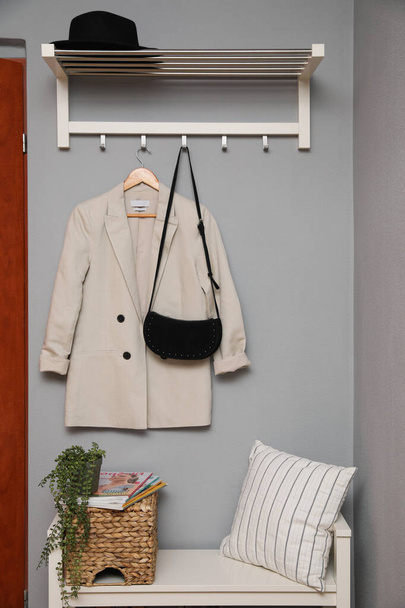 Bench and coat rack on grey wall in hallway. Interior element - Photo, image