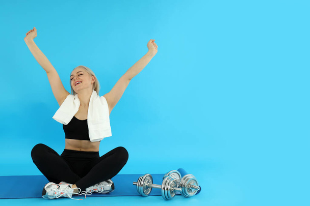 Konzept eines gesunden Lebensstils mit sportlicher Frau auf blauem Hintergrund - Foto, Bild