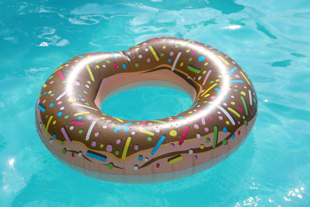 Inflatable ring floating on water in swimming pool - Fotoğraf, Görsel