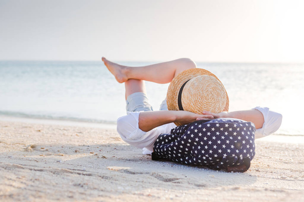 Summer beach vacation concept, caucasian woman with hat relaxing on the beach near ocean - Foto, Imagen