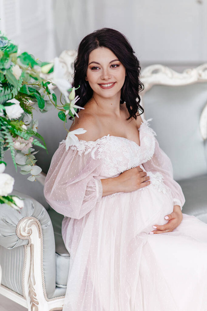 Beautiful pregnant girl in a dress in a bright room - Foto, Imagem