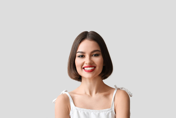 Портрет красивой женщины с красной помадой на светлом фоне - Фото, изображение