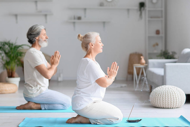 Coppia matura che pratica yoga a casa - Foto, immagini