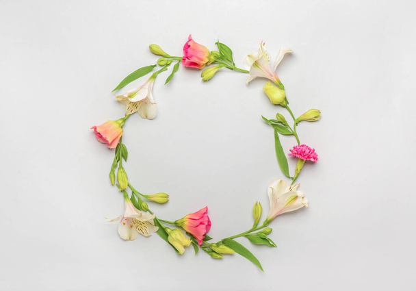 Kehys valmistettu alstroemeria, eustoma ja neilikka kukkia valkoisella pohjalla - Valokuva, kuva