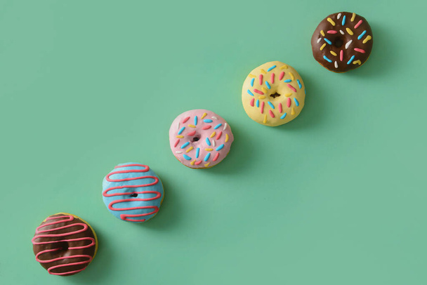 Different sweet donuts on color background - Foto, imagen