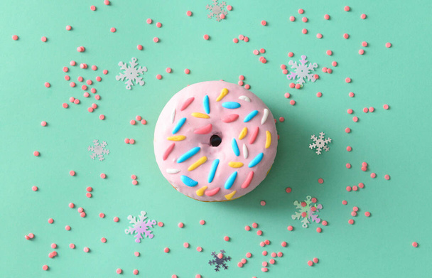 Sweet donut and sprinkles on color background - Foto, Imagen