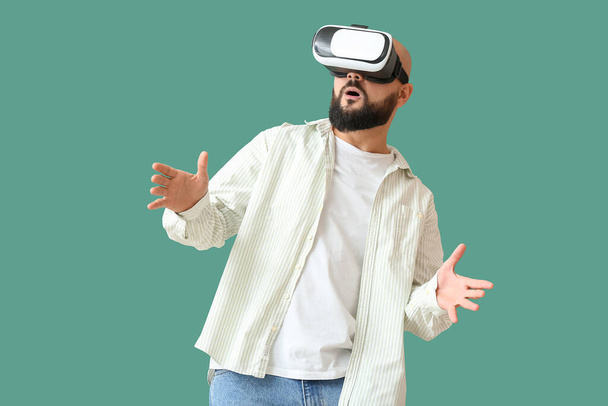 Bald man with VR glasses on green background - Photo, image