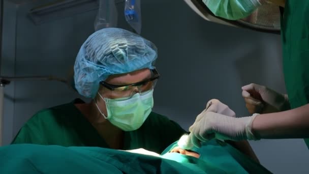 Niski kąt ujęcia Profesjonalny zespół chirurgów wykonujących operacje na sali operacyjnej, chirurga, asystentów i pielęgniarek Wykonywanie operacji na pacjencie, opieki zdrowotnej nowotworu i koncepcji leczenia choroby - Materiał filmowy, wideo