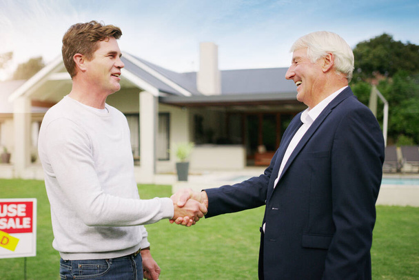 Hiciste la compra correcta. Fotografía de un joven reuniéndose con un agente inmobiliario en su casa recién comprada. - Foto, Imagen
