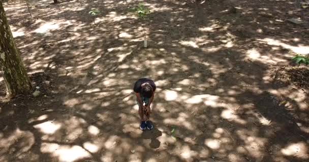 mladý muž běží ve dne se zeleným parkem v pozadí - Záběry, video
