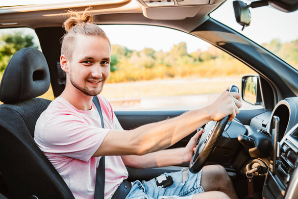 mladý pohledný sebevědomý muž řídí auto. výlet - Fotografie, Obrázek