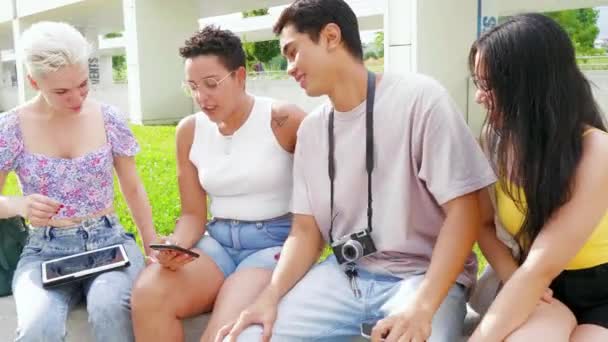 Group of multiethnic young friends outdoors using smartphone watching video, doing business or trading online - Footage, Video