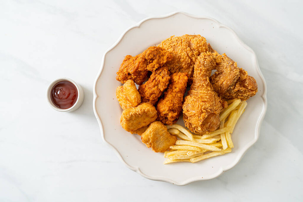 fried chicken with french fries and nuggets on plate - unhealthy food - Fotó, kép