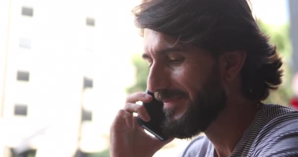 Boční pohled na mladého muže pomocí smartphonu doma - Záběry, video