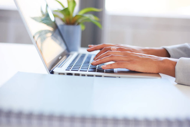 Uma jovem mulher mãos digitando em um laptop no escritório - Foto, Imagem