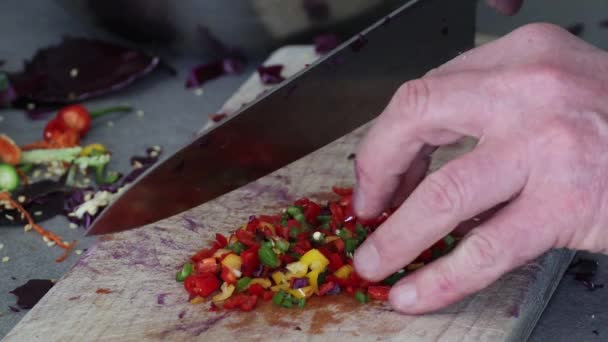 Hacher des piments sur une planche de bois avec un couteau - Séquence, vidéo