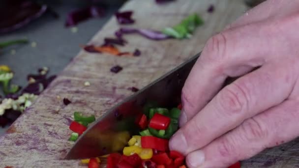 Chilischoten mit einem Messer auf einem Holzbrett hacken - Filmmaterial, Video