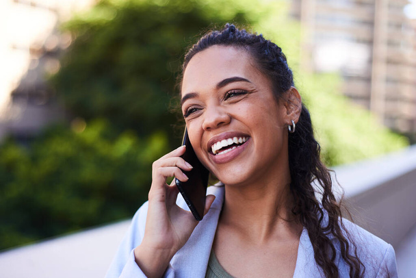Genç bir kadın balkonda telefonda konuşurken gülümsüyor ve gülüyor. - Fotoğraf, Görsel