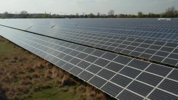Linhas de células solares montadas em construções no solo. Fonte de energia renovável. Conceito de energia verde, ecologia e redução da pegada de carbono - Filmagem, Vídeo