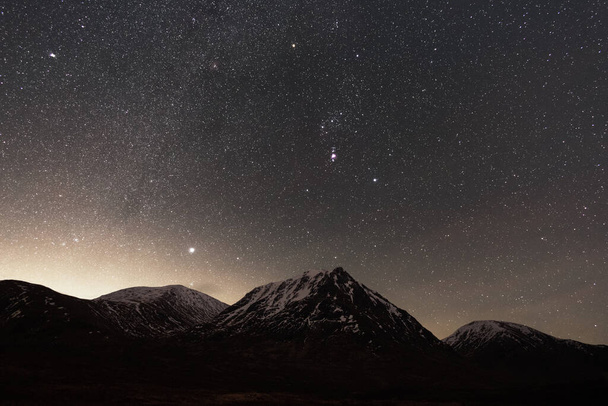 Glen Etive astrophotography with the Milky Way and Orion rising above a snowy mountain peak - Photo, Image