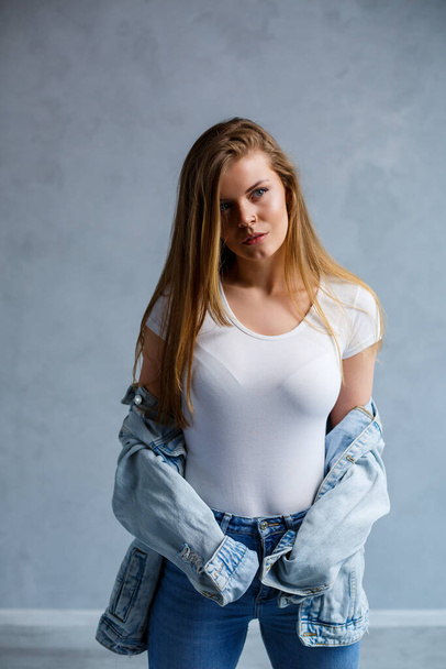 Close-up portrait of a young beautiful woman with blond hair of European appearance. Dressed in a white T-shirt. Emotional photo of a person - Foto, Imagem