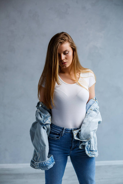 Close-up portrait of a young beautiful woman with blond hair of European appearance. Dressed in a white T-shirt. Emotional photo of a person - Foto, imagen