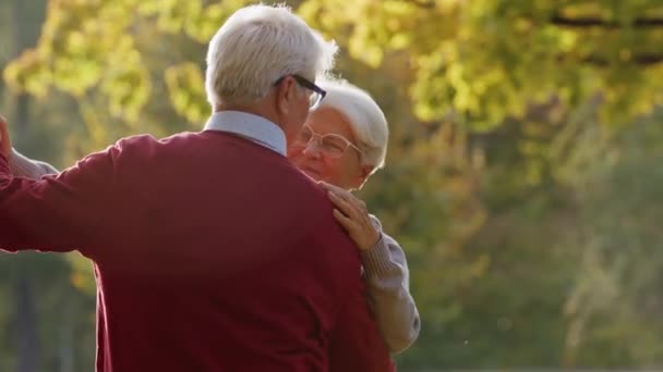 Šťastný starý pár tanec v podzimním parku - střední záběr - Záběry, video