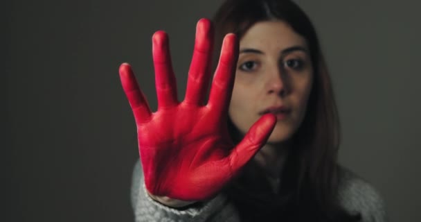 Chica triste levanta la mano pintada de rojo para parar y protestar contra la violencia - Metraje, vídeo