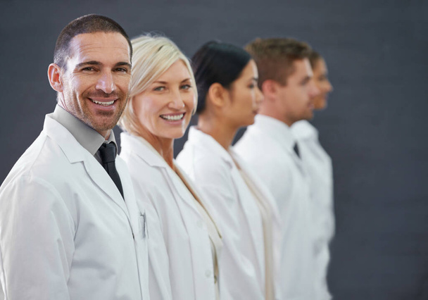 Your first line of defense against illness. Cropped shot of a group of doctors standing in a row. - Foto, afbeelding