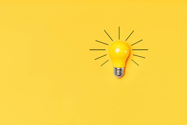 Concept creative idea with lightbulb on yellow background - Фото, изображение