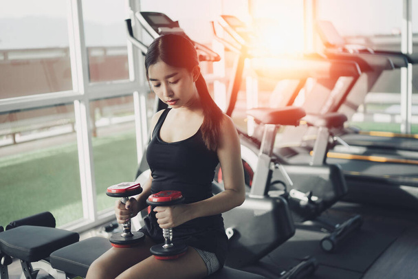 Mujer deportiva asiática en forma haciendo ejercicio en la sala de pesas en el gimnasio. Deporte concepto de fitness mujer - Foto, Imagen