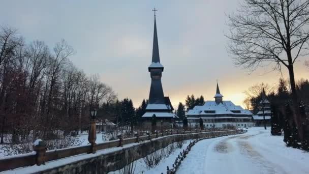Kilátás a Peri-Sapanta kolostorra télen, Romániában. Fő templom és épületek, csupasz erdő és hó körül - Felvétel, videó