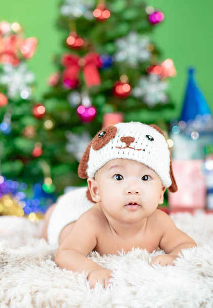 Felice anno nuovo albero di Natale con carino bambino che indossa costume cane uncinetto maglia. - Foto, immagini