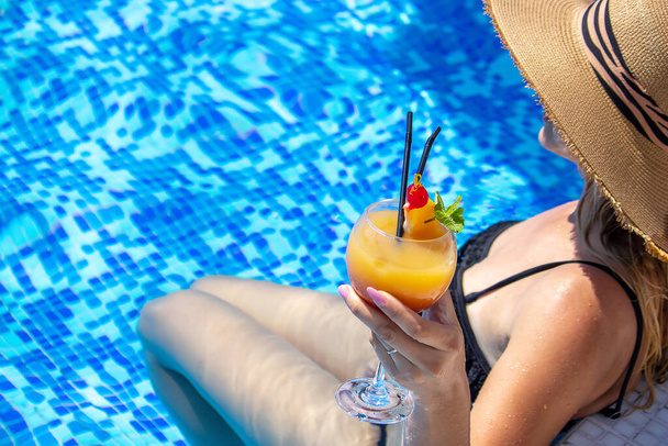 girl drinks a cocktail in the pool. Nature. selective focus - Φωτογραφία, εικόνα