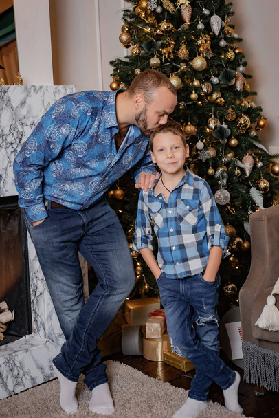 Πατέρας και γιος κοντά στο χριστουγεννιάτικο δέντρο. Ημέρα του Πατέρα. - Φωτογραφία, εικόνα
