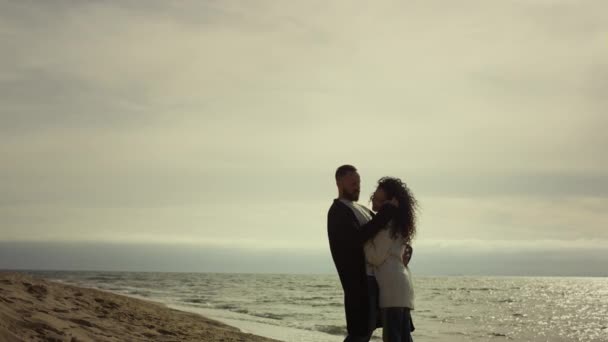 Egy pár ölelik egymást a tengeren. Szerető emberek ölelkeznek az óceán partjainál. - Felvétel, videó