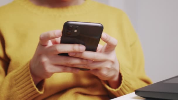 閉じる手を閉じますアジアの女性は、自宅で彼女のスマートフォンで電話メッセージや入力メッセージに応答するデスクの上に座って. - 映像、動画