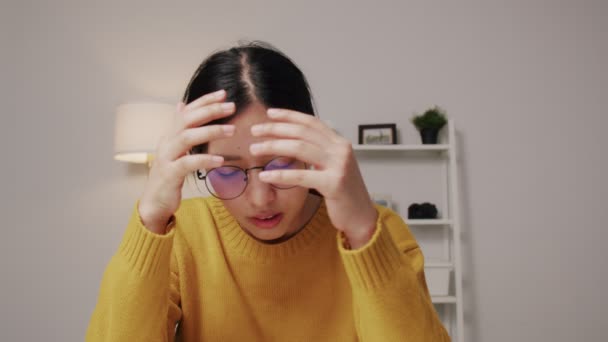 Depresyondaki Asyalı kadın ellerini kafasına koyunca işi konusunda umutsuz hissediyor. Dramatik ve duygusal konsept. - Video, Çekim