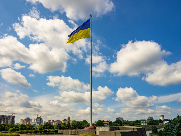 Biggest National Flag of Ukraine on tall flagpole in dowmtown of Kyiv, capital of Ukraine. Picturesque blue sky background - Foto, imagen