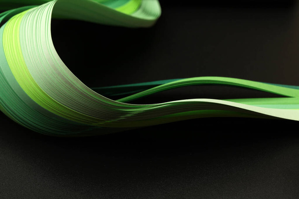 Green color strip wave paper. Abstract texture black background. - Foto, afbeelding