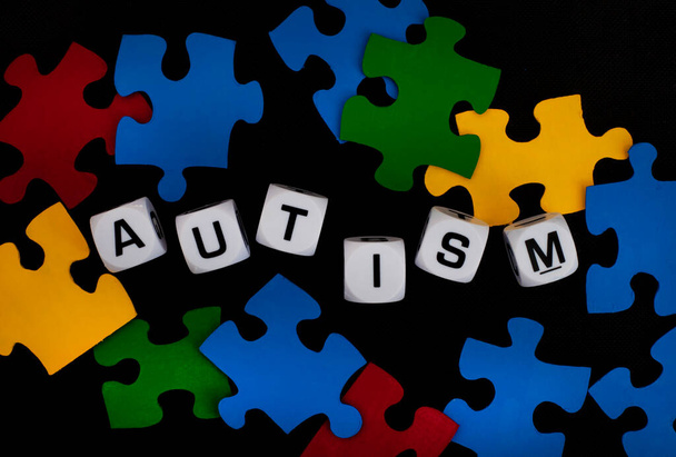 Autisme gespeld in letters dobbelstenen met puzzelstukjes - Foto, afbeelding