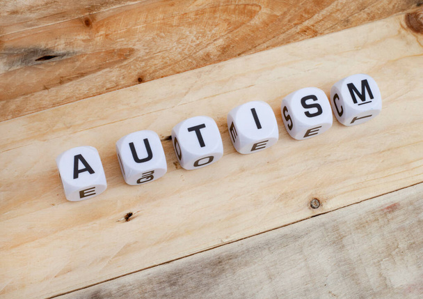 Autismus buchstabiert in Buchstabenwürfeln mit Puzzleteilen - Foto, Bild