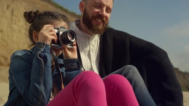 Een klein kind dat foto 's maakt op een familie strandreis. Schattig meisje houden camera buiten. - Video