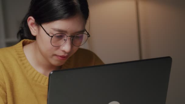 HANDHELD SHOT: Aziatische zakenvrouw met behulp van laptops werken vanuit huis en zorgen voor hun gezondheid van COVID-19. Sociaal afstandconcept. - Video