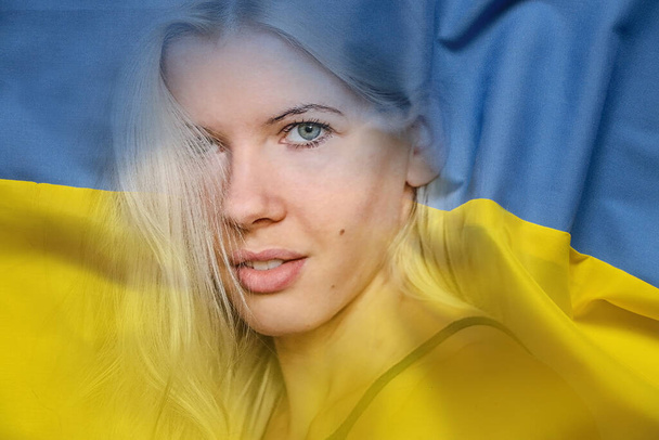 ウクライナの黄青色の国旗と少女の顔、ウクライナの戦争と平和、ウクライナの自由、戦争を停止する2022 - 写真・画像